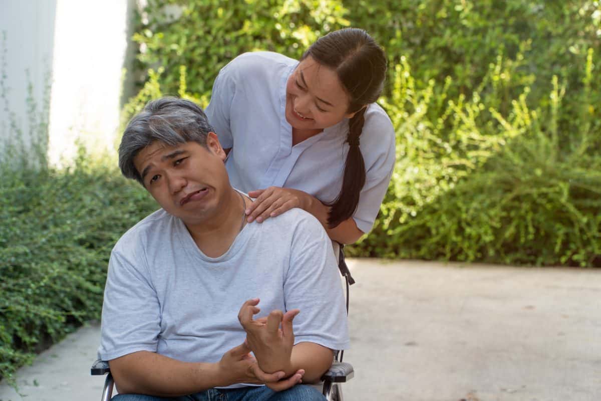 The patient is Cerebrovascular accident or stroke Caused by hypertension and obesity, sitting in wheelchair him mouse is facial palsy, him wife takes care. Concept of healthcare and medical service